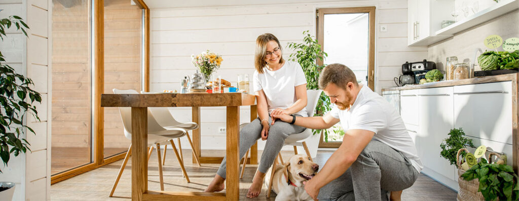A man holding a seated woman’s hand while petting a dog